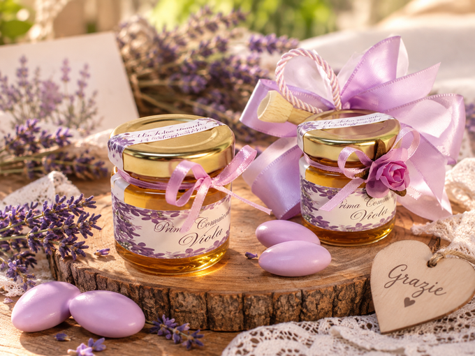 Vasetti di miele alla lavanda con nastri e caramelle a forma di cuore su una fetta di legno, con fiori viola e un'etichetta con la scritta