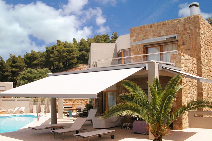 Villa moderna con tende da sole bianche, piscina e palme in un soleggiato resort.