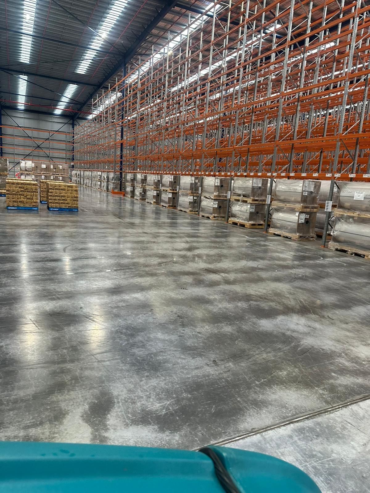 Aerial view inside large distribution warehouse with high racking and wide aisles
