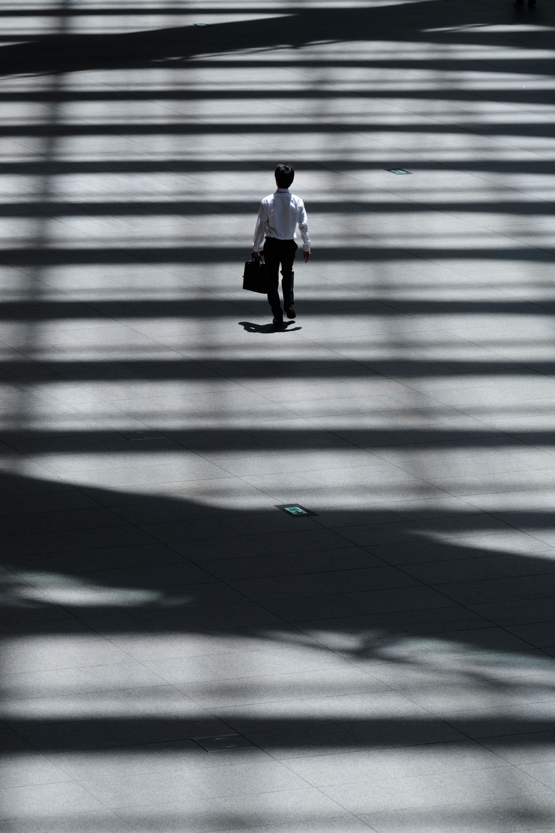 A man with a briefcase is walking across a crosswalk