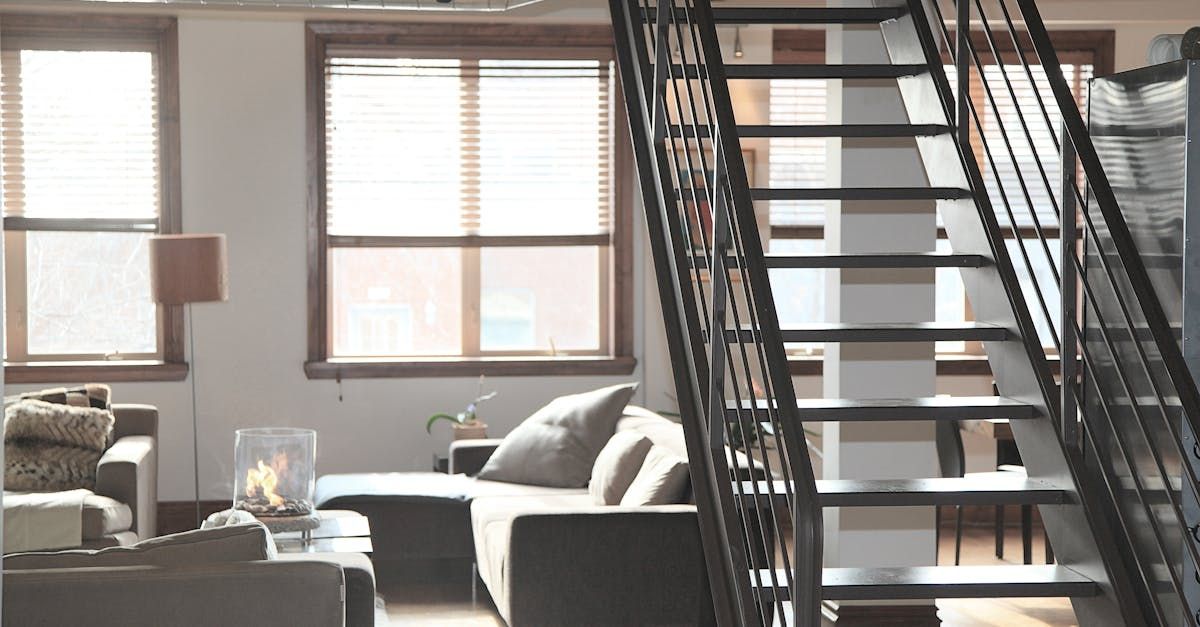 A living room with a staircase leading up to the second floor.
