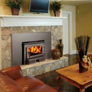 Fireplace with stone surround, wood-burning stove, TV, and living room furniture.