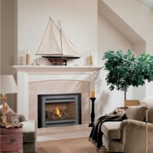 Fireplace with mantel, sailboat, candles, and armchair in a living room.