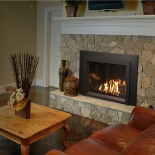 Fireplace in a living room with stone surround, lit flames, and a wooden coffee table.