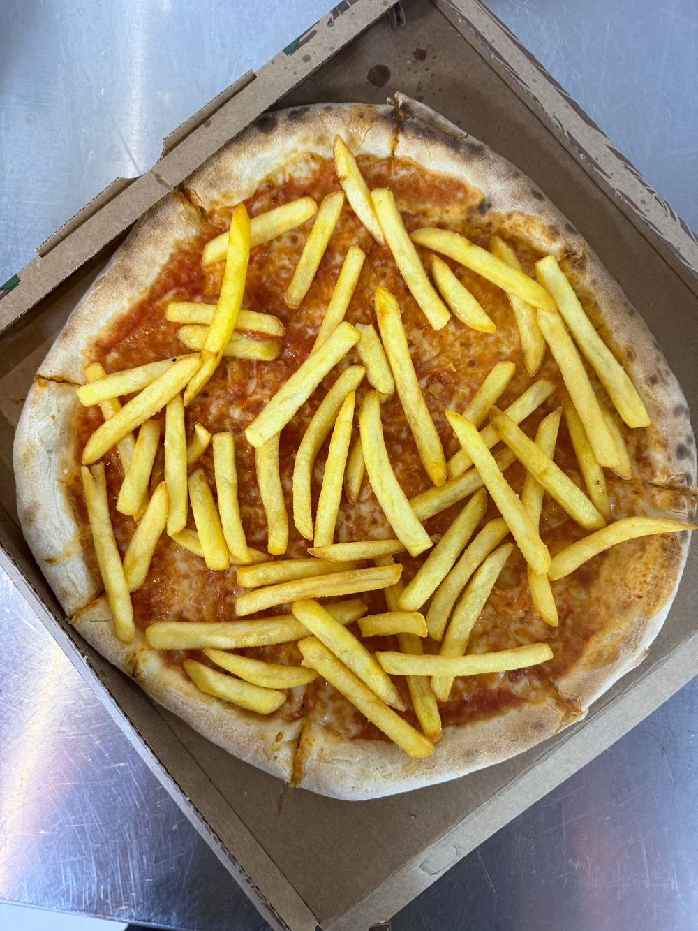 Un calzone dorato a fette su un piatto accanto a una forchetta e un coltello, con l'insegna