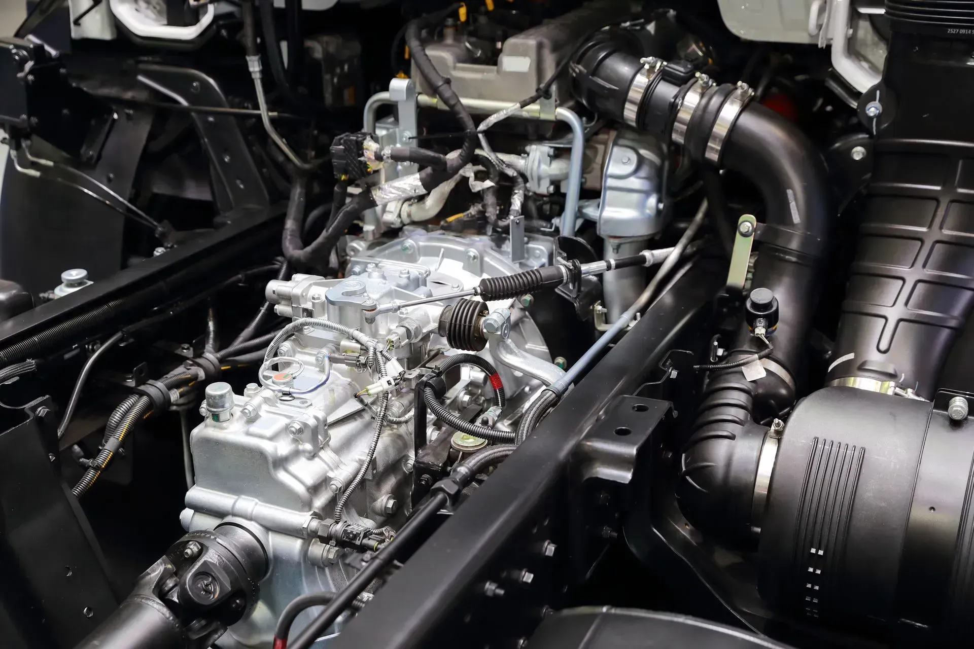 Close-up of a polished car engine with black hoses and metallic components in the engine bay