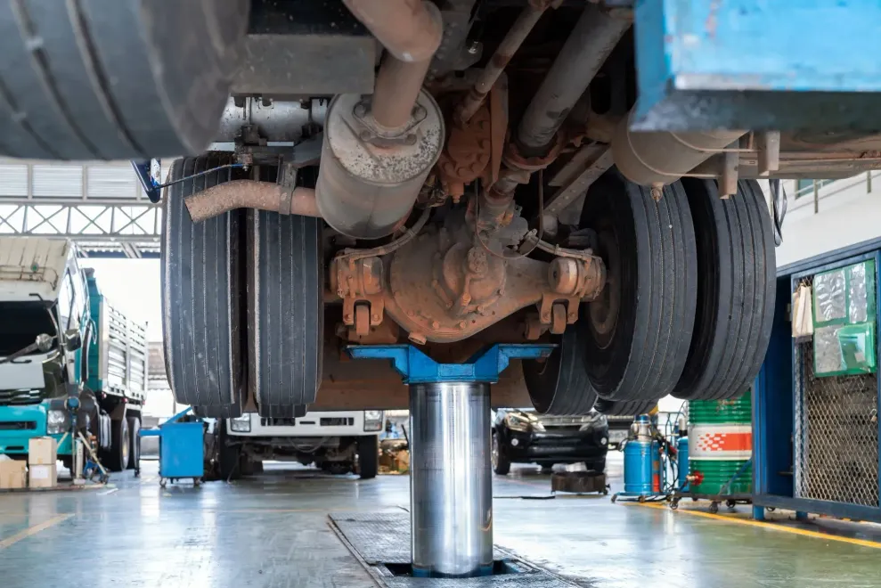 Truck undercarriage lifted on a hydraulic jack in an auto repair shop