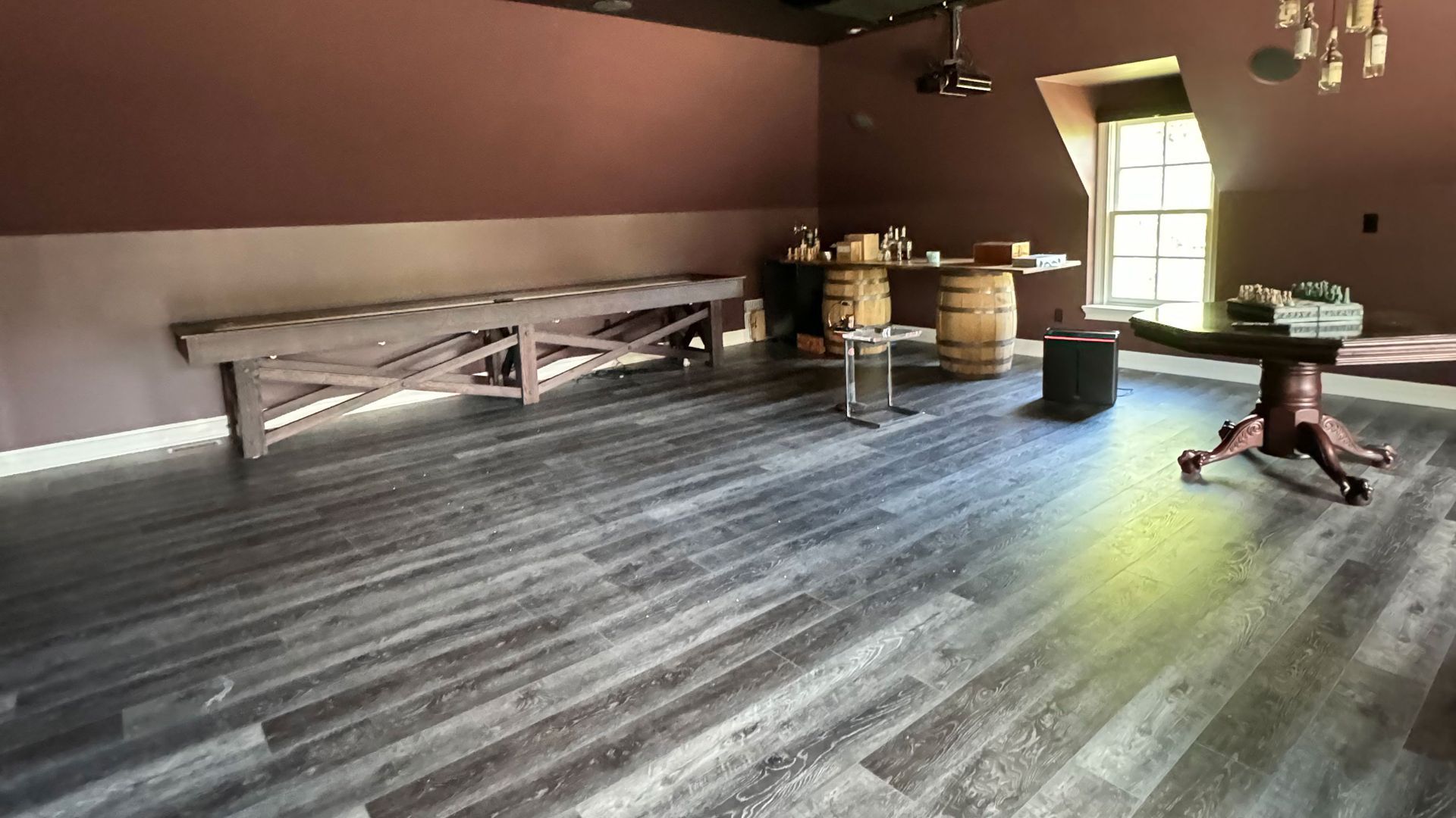 A room with wooden floors , a table , benches and barrels. A room with wooden floors , a table , benches and barrels.