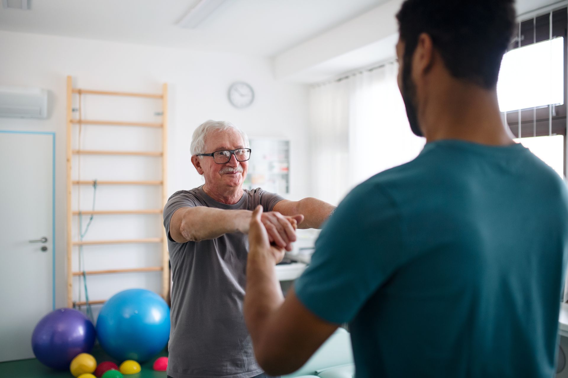 Senior patient performing orthopedic physical therapy exercises with a therapist