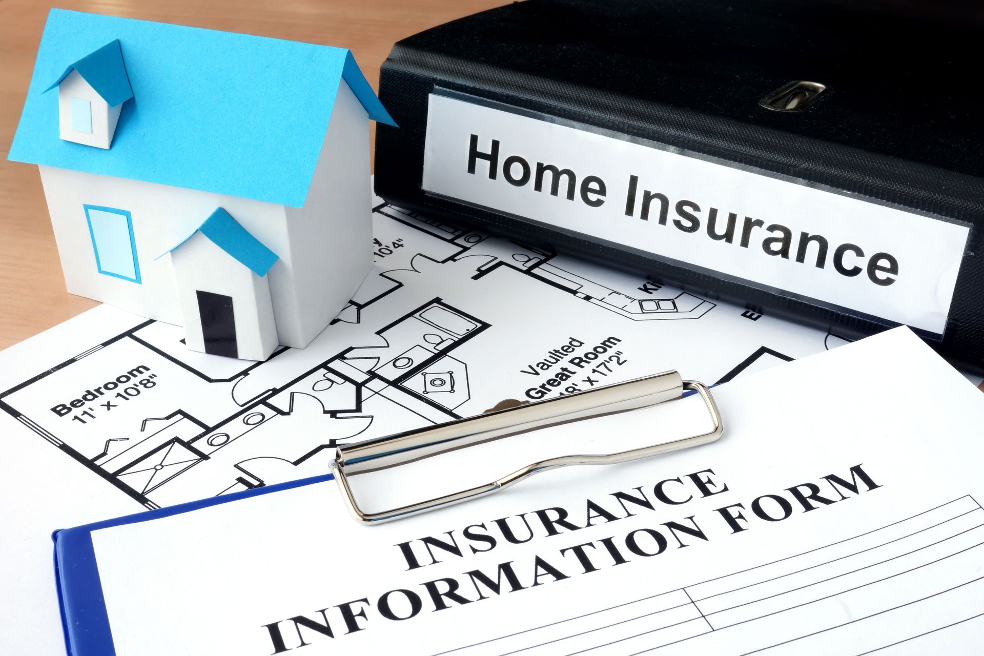 Model of house and folder with home insurance.