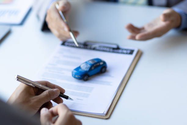 Renters Insurance Concept- Businessman signing car purchase, lease contract agreement with car sales