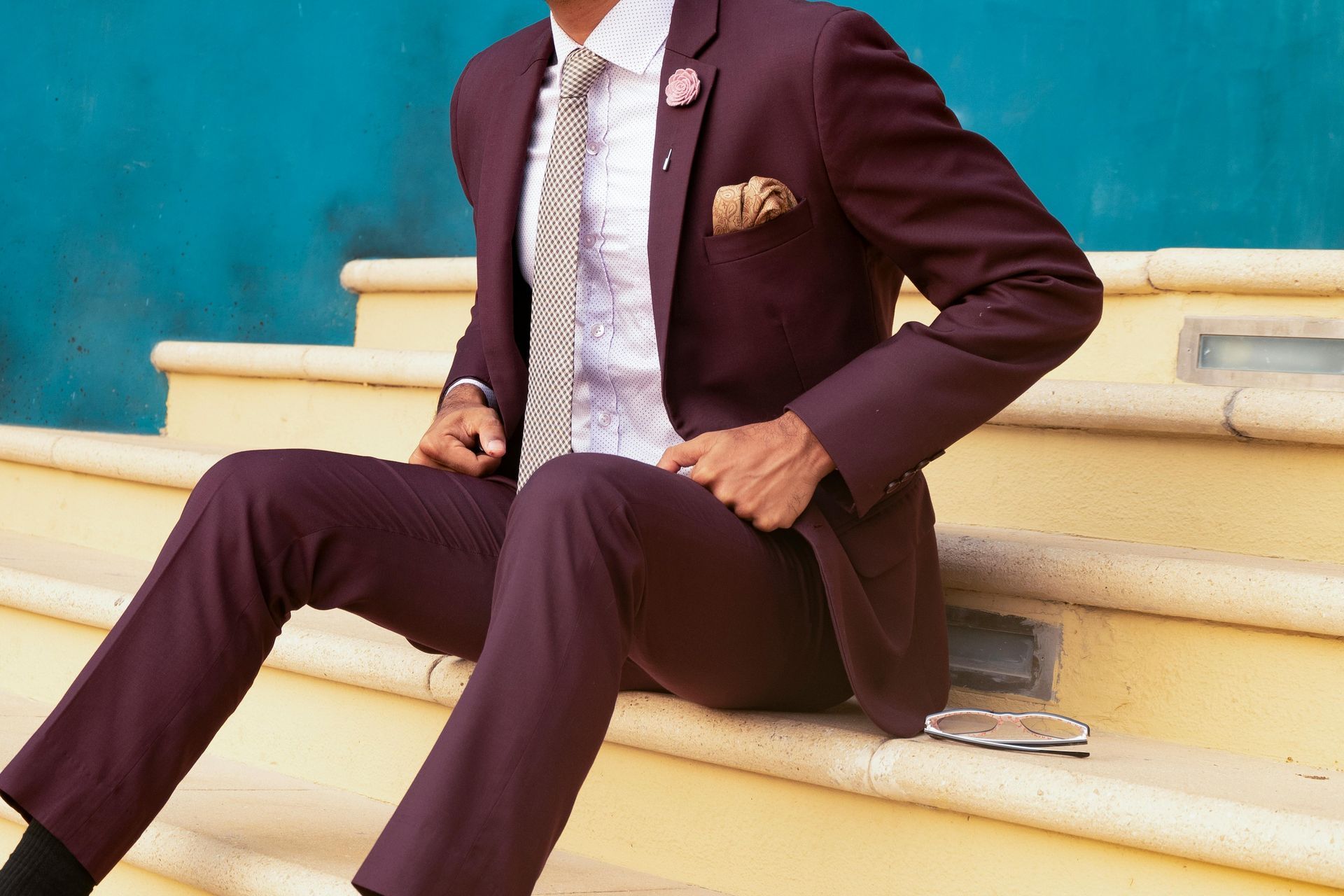 A man in a suit and tie is sitting on a set of stairs.