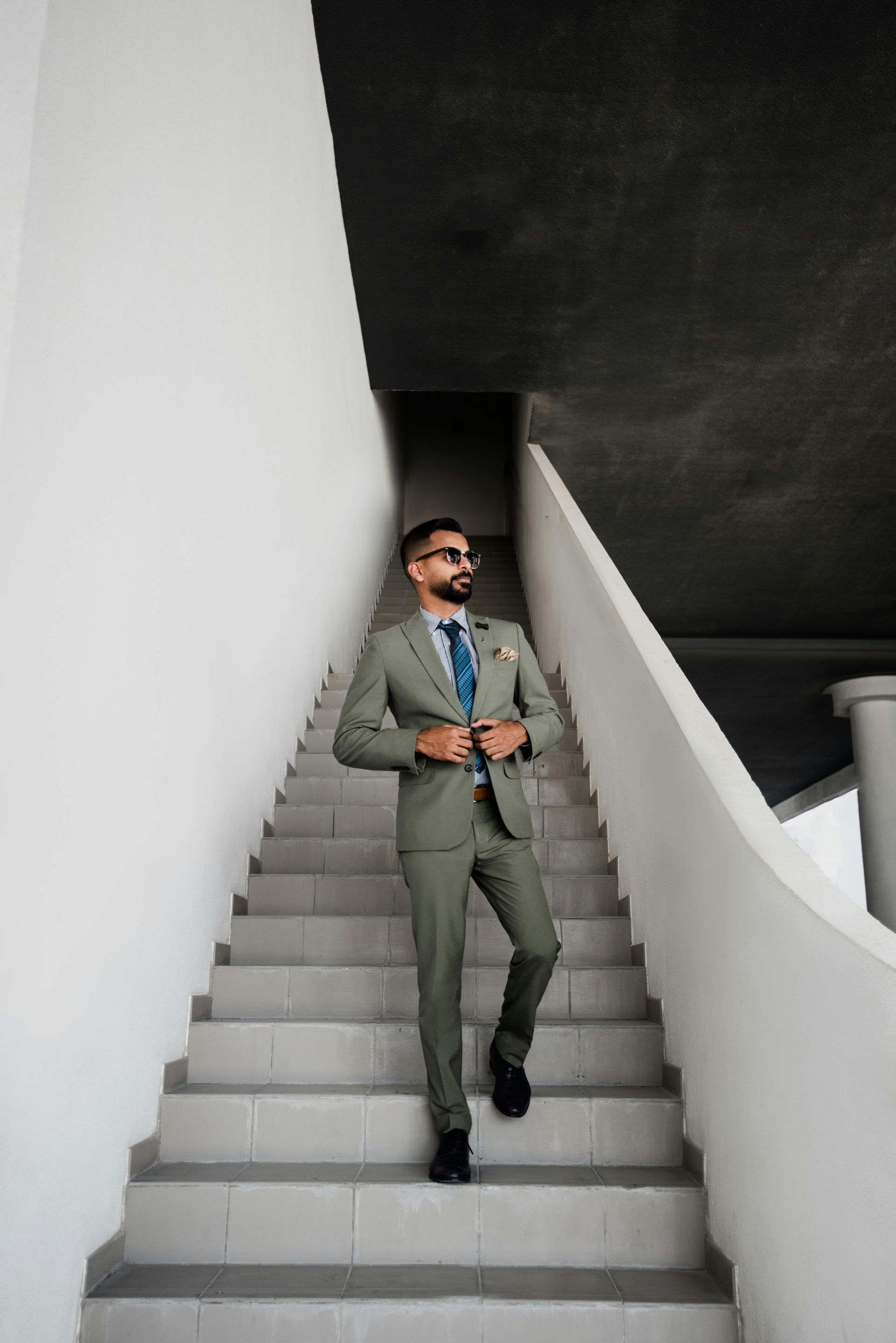 A man in a suit and tie is standing on a set of stairs.