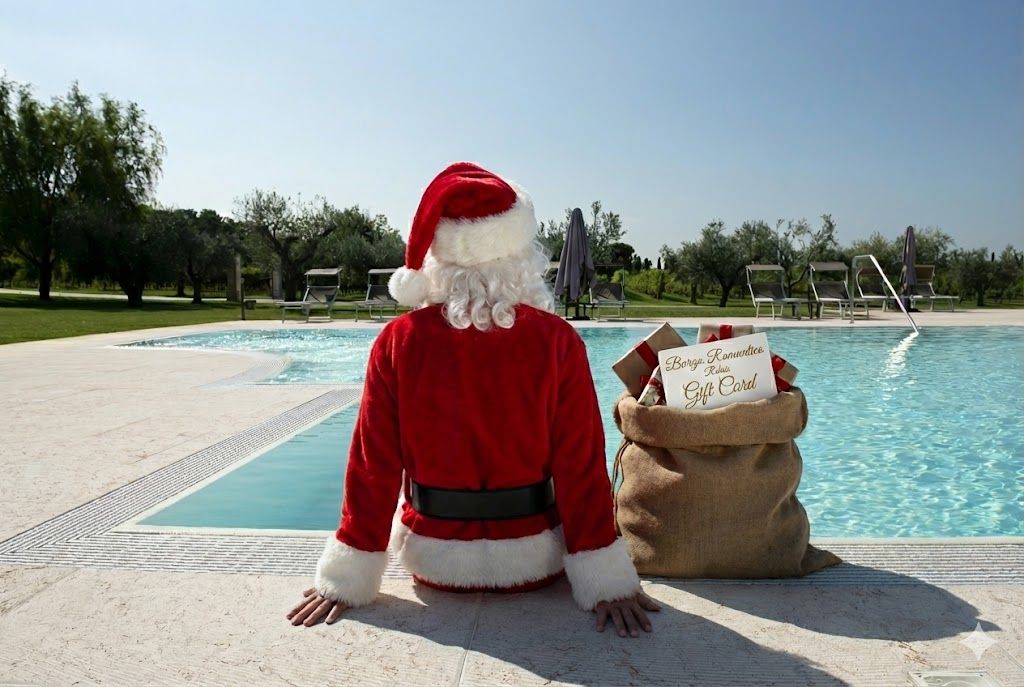 Babbo Natale seduto a bordo piscina con un sacco di regali in una giornata di sole