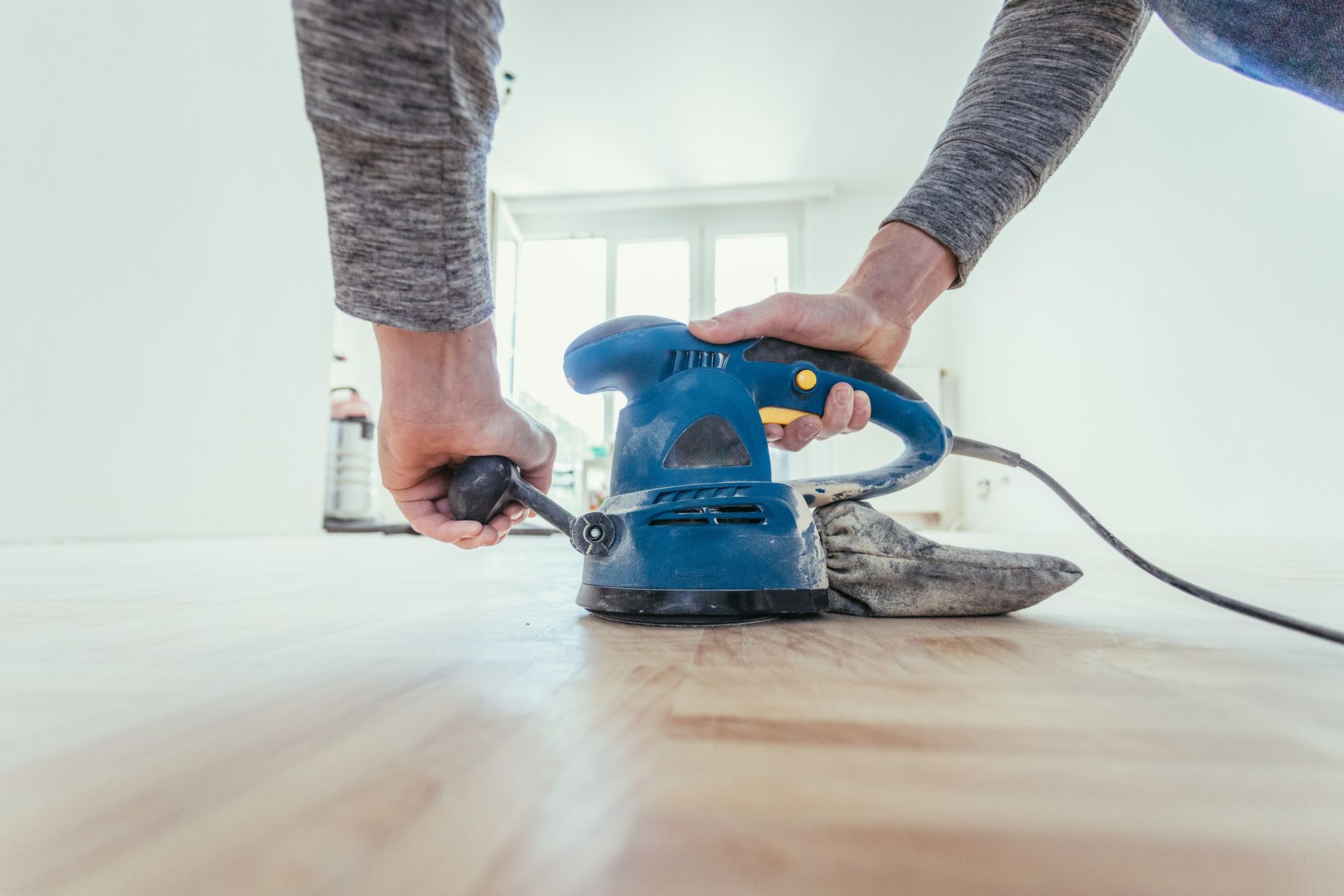 A man is using a sander power tool.