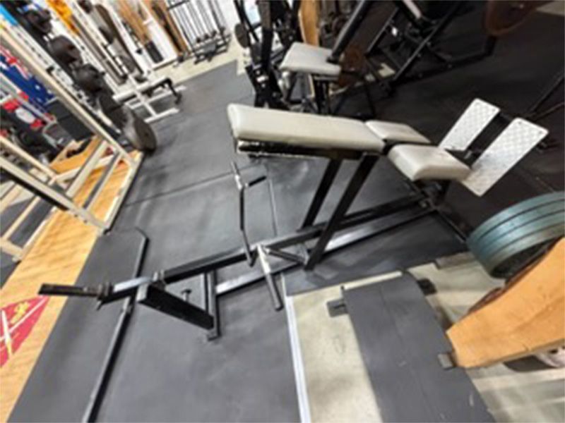 Gym equipment with a hyperextension bench on black rubber flooring