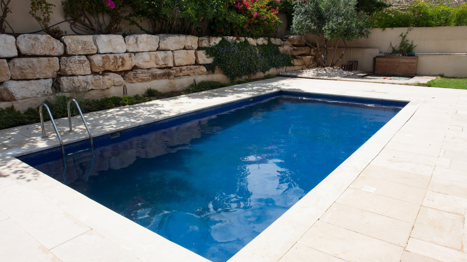 Picture of a concrete pool deck in a backyard.