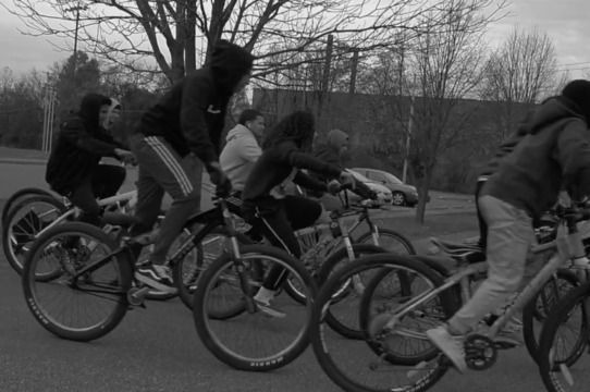 A black and white photo of a group of people riding bicycles