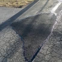 Close-up of a dark crack or seam running diagonally across a gray paved surface