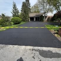 Close-up of a cracked asphalt surface with a long dark seam or fissure running diagonally