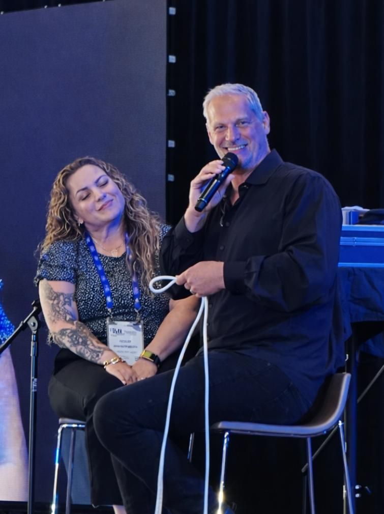 Two people seated on stage