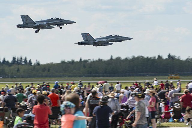 Two F18 jets flying at Cold Lake Air Show in front of a large crowd