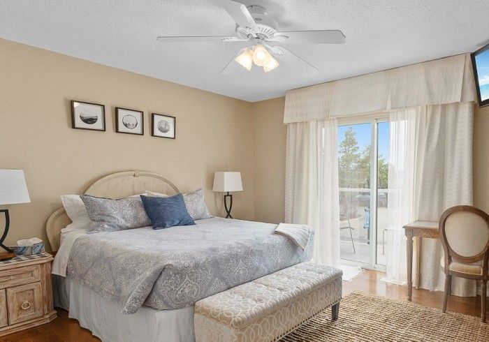 A bedroom with a king size bed and a ceiling fan. Lakeshore Inn Bed & Breakfast