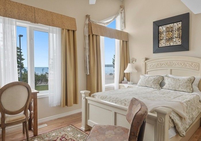A bedroom with a bed , chair , desk and window Lakeshore Inn Bed & Breakfast