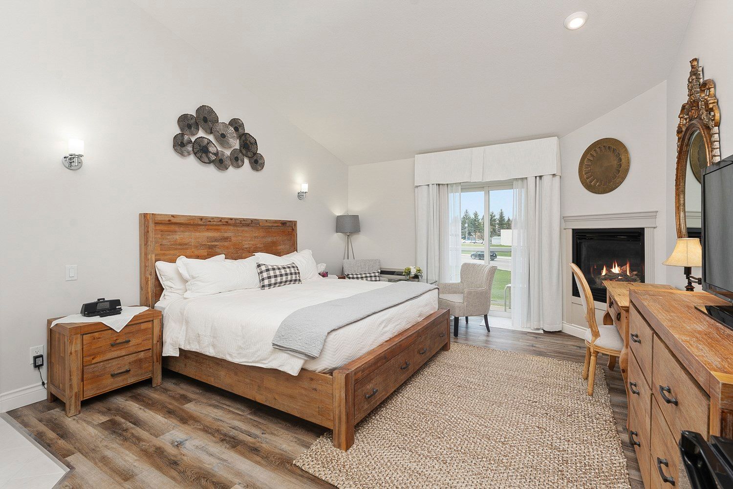 A hotel room with a king size bed , desk , chair and television. Lakeshore Inn Bed & Breakfast