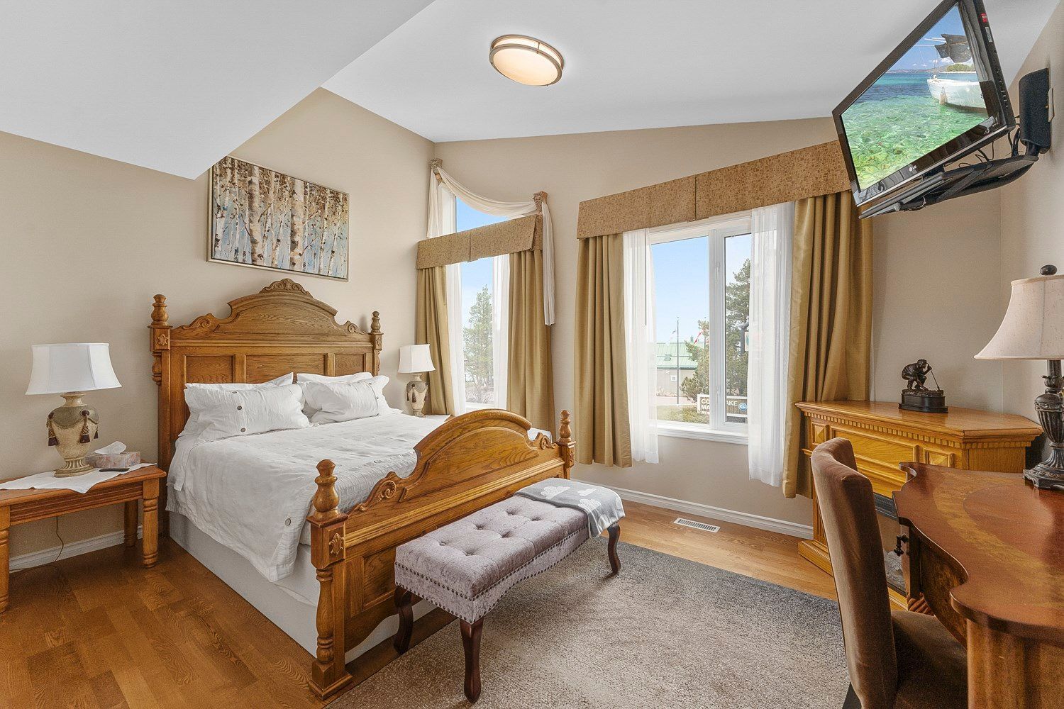 A bedroom with a large bed and a flat screen tv. Lakeshore Inn Bed & Breakfast