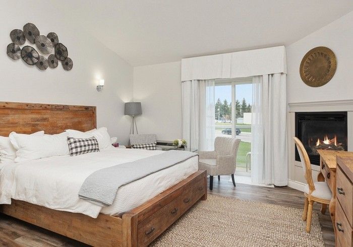 A bedroom with a king size bed and a fireplace Lakeshore Inn Bed & Breakfast