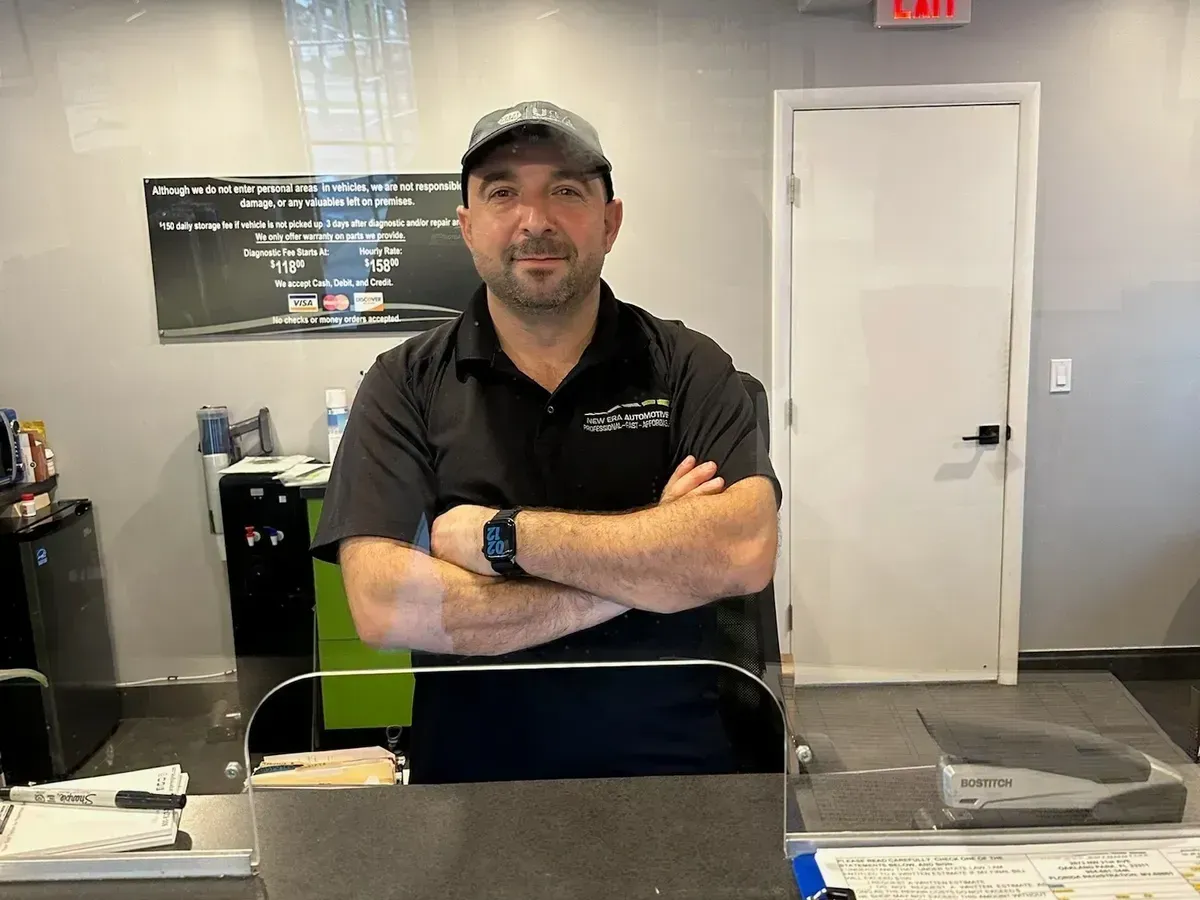 New Era Automotive Owner At Front Desk Providing Customer Assistance | New Era Automotive