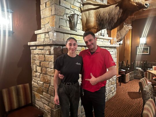 server smiling holding trays of food