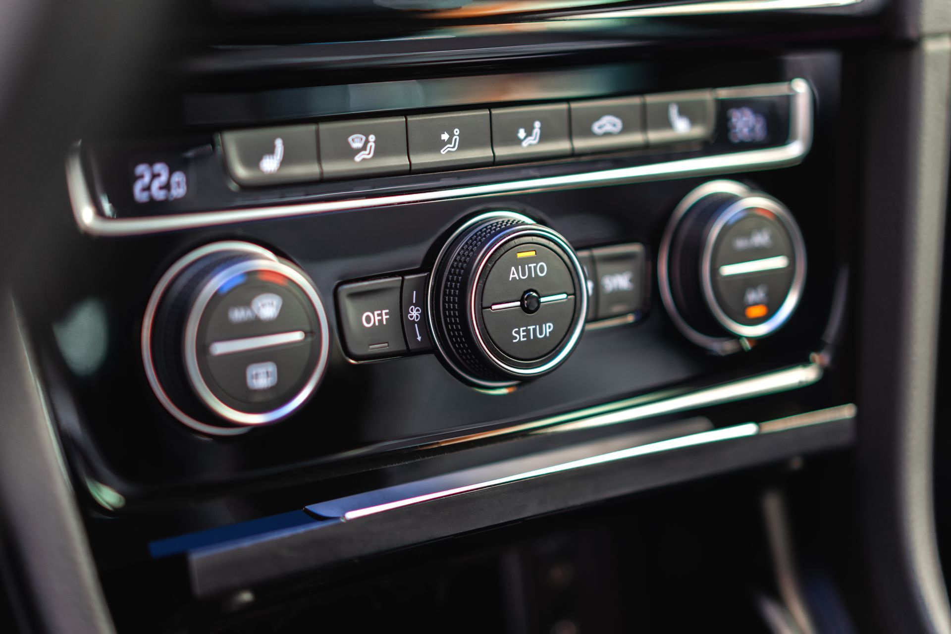 Car climate control panel with digital display and circular temperature dials in a black dashboard | Quality Auto Repair Tire & Auto Sales