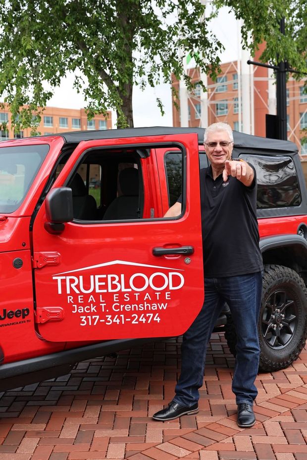 Man in red Jeep points, logo