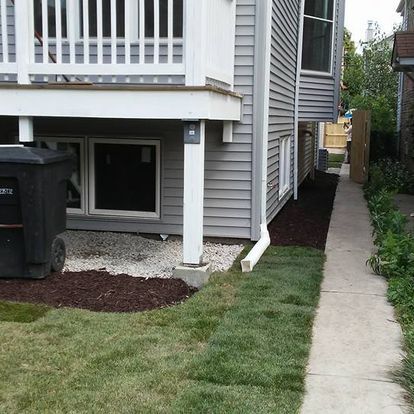 A house with a black trash can in front of it