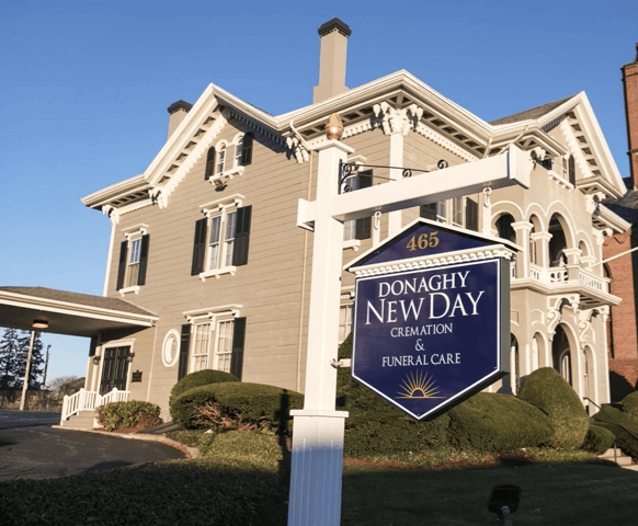 Exterior view of a gray Victorian building with sign