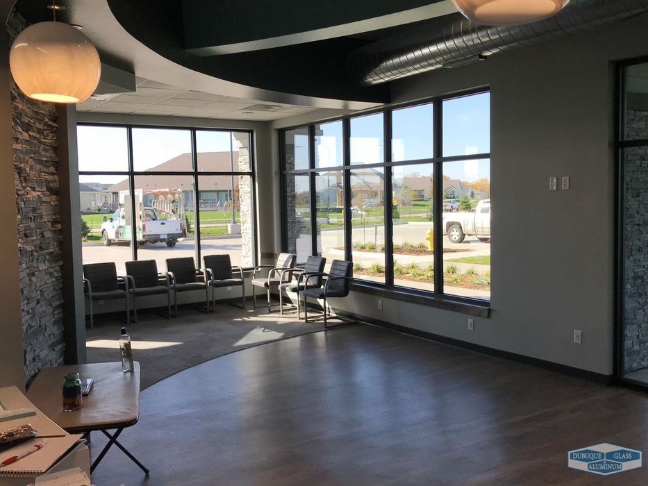Modern lobby seating area with large windows and dark flooring