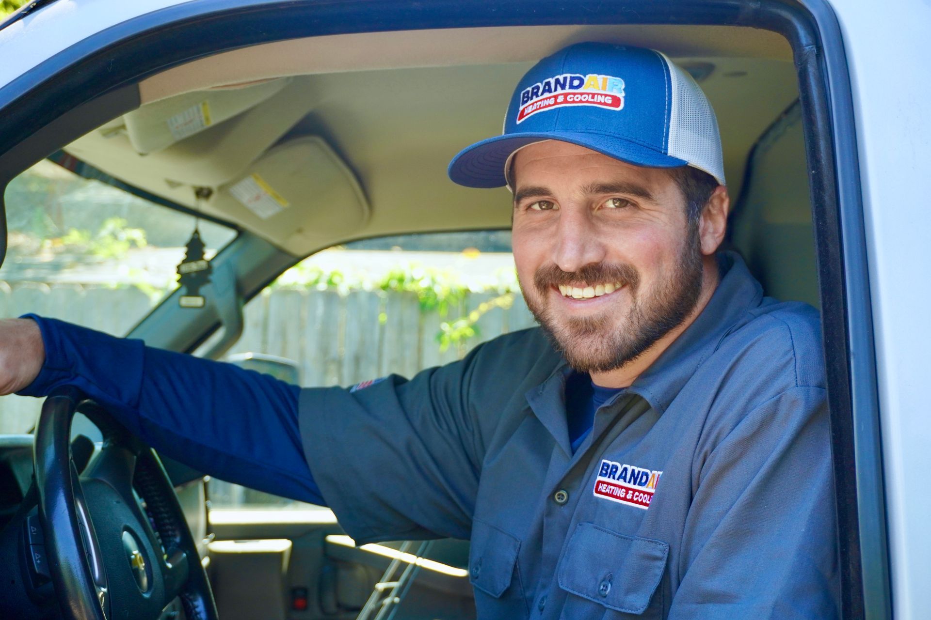 A man in a blue shirt is smiling for the camera.
