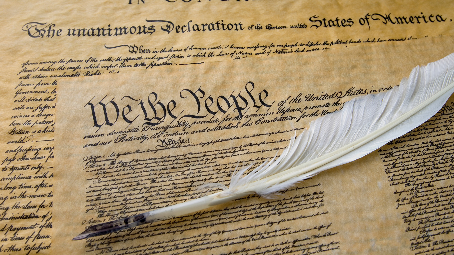 Declaration of Independence parchment with quill pen on a textured surface
