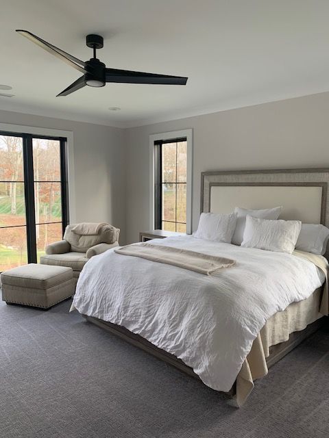 A bedroom with a large bed and a ceiling fan, regular cleaning for Clean Crew in Cincinnati, OH.
