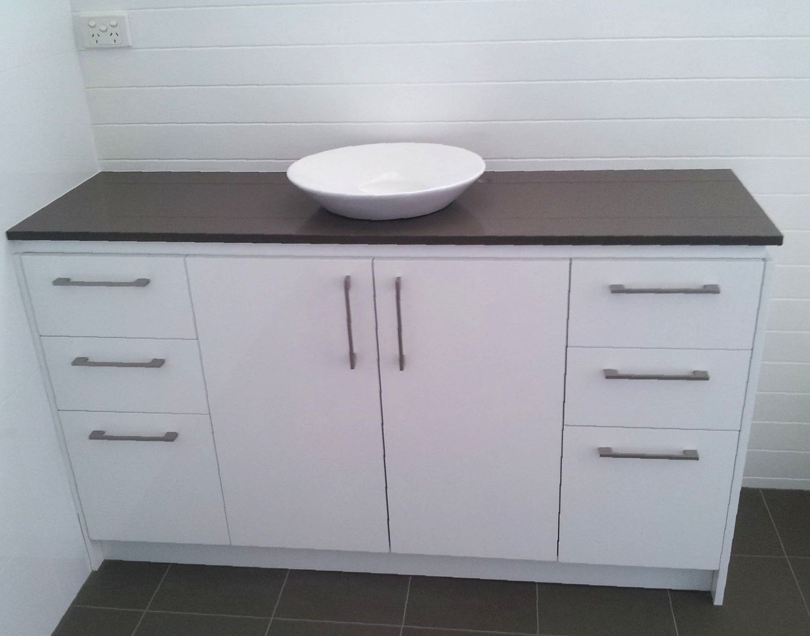 Toilet Beside Vanity Unit With Sink Mirror And White Cabinets Inside Bathroom — Laundry & Bathroom Vanities in Nambucca Heads, NSW