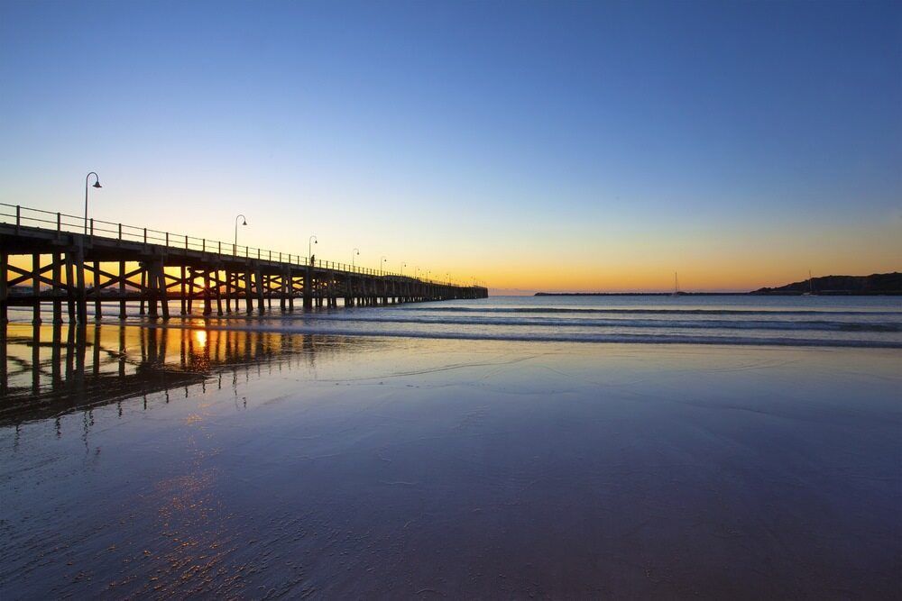 A Pier Overlooking a Body of Water at Sunset — Custom Cabinetry & Kitchen Renovations in Coffs Harbour, NSW