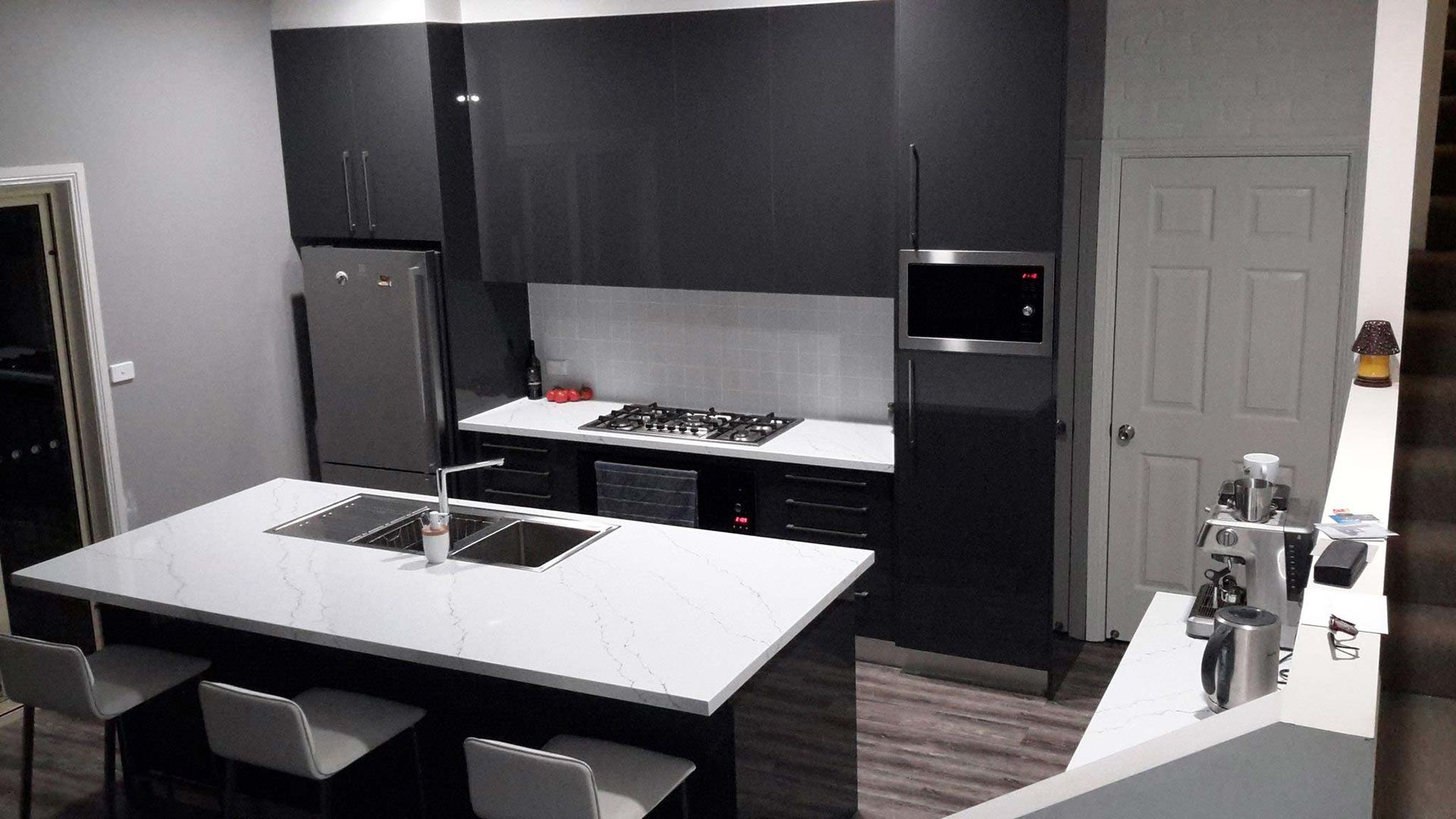 A Kitchen with Black Cabinets and A White Counter Top — Custom Cabinetry & Kitchen Renovations in Port Macquarie, NSW