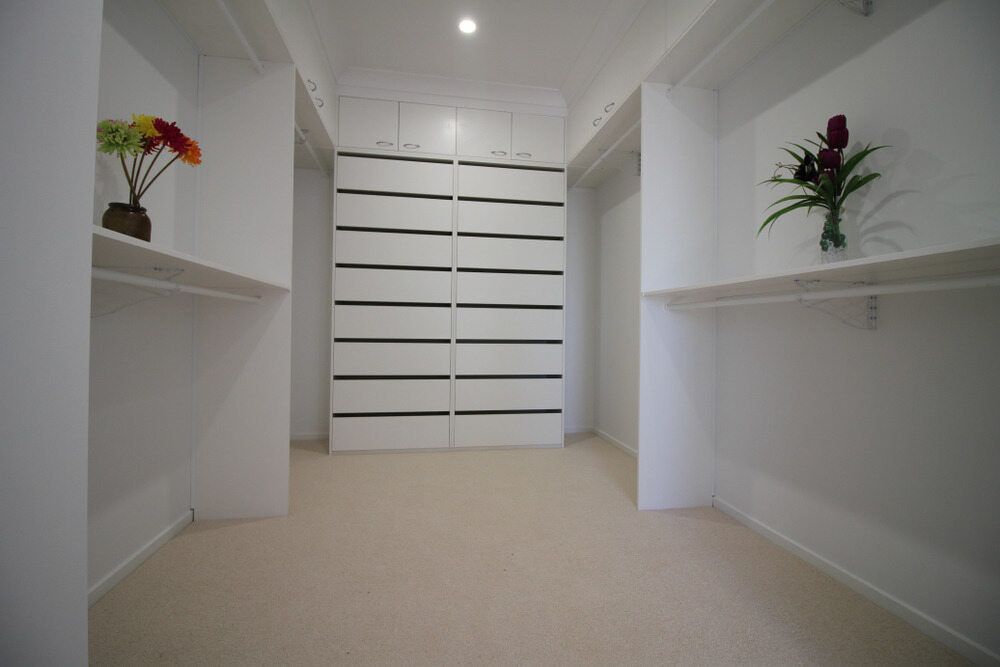 An Empty Walk in Closet with A Vase of Flowers on The Shelf — Amazing Kitchen Renovations in Nambucca Heads, NSW