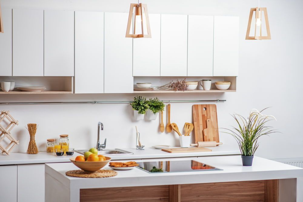 A Kitchen with White Cabinets , a Wooden Counter Top , a Sink , and A Bowl of Fruit on The Counter — Custom Cabinetry & Kitchen Renovations in Nambucca Heads, NSW