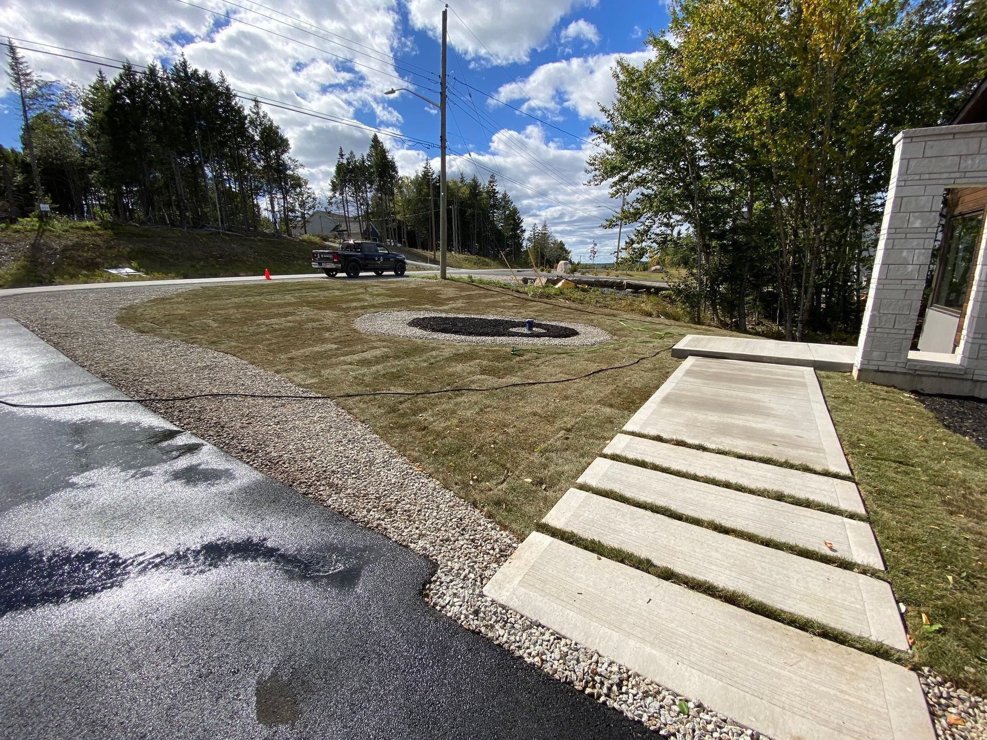 a car is driving down a road next to a concrete walkway .