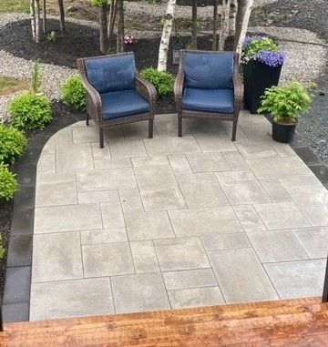 there are two chairs on the patio with blue cushions .