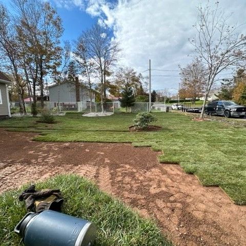 a lawn mower is sitting in the grass in front of a house .