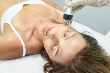 Un dentista esamina la bocca di un paziente con uno specchietto dentale in una sala operatoria.